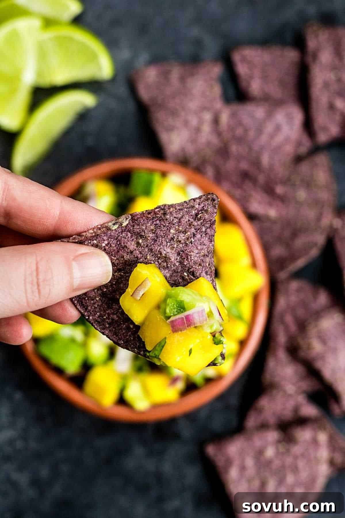holding a chip with Mango Salsa