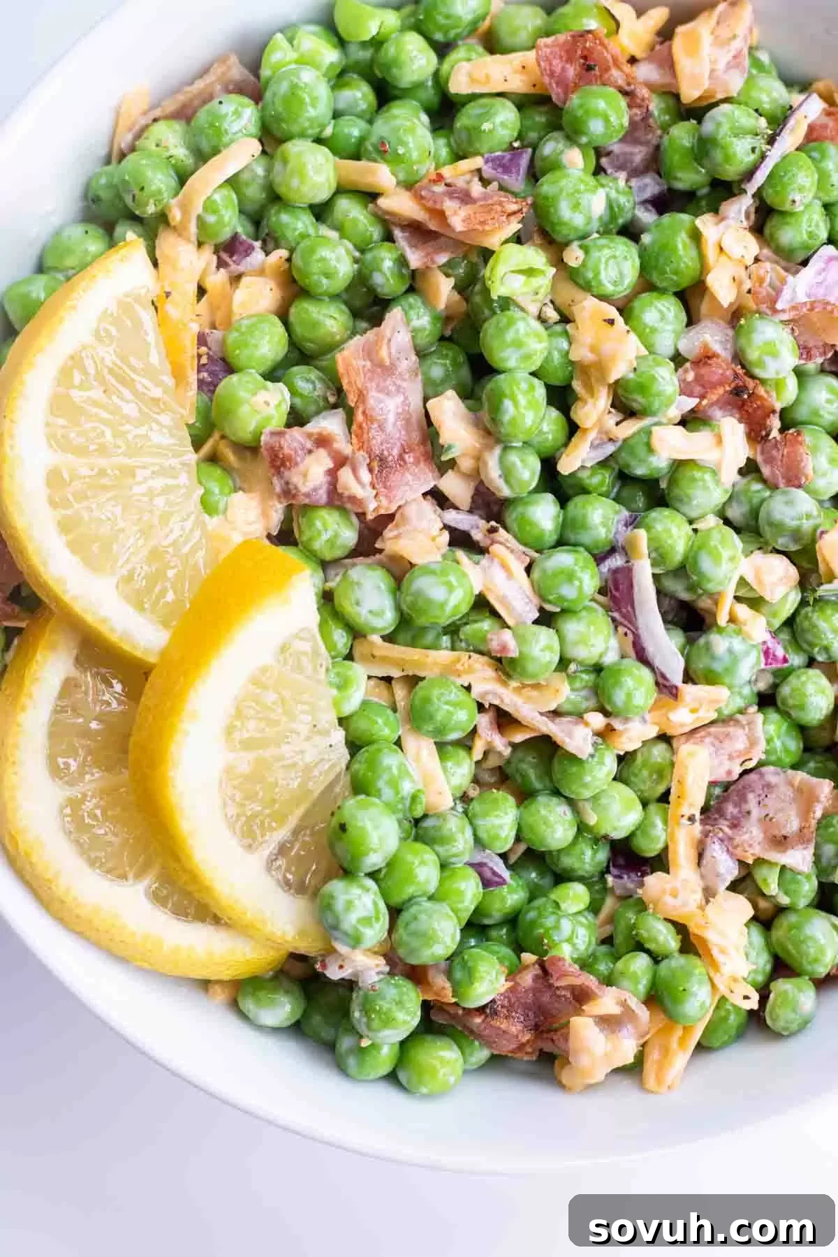 Velvety Spring Pea Salad 9 english pea salad in a white bowl with lemon slices