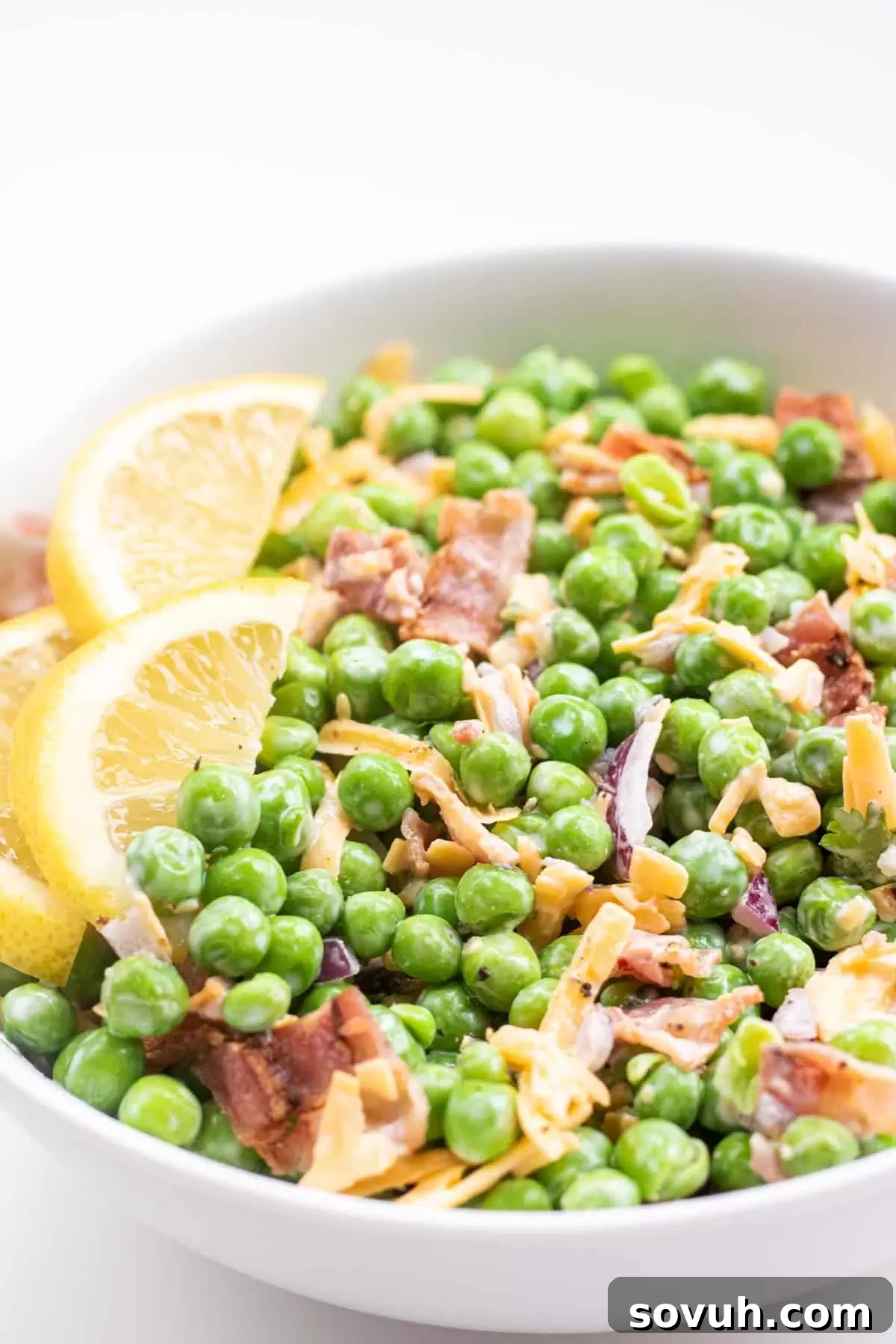 Velvety Spring Pea Salad 10 english pea salad in a white bowl with bacon and cheddarcheese