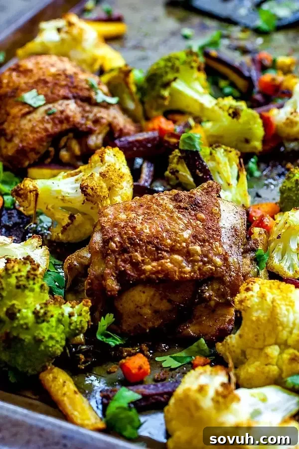 Raw chicken thighs coated in curry seasoning and olive oil in a bowl