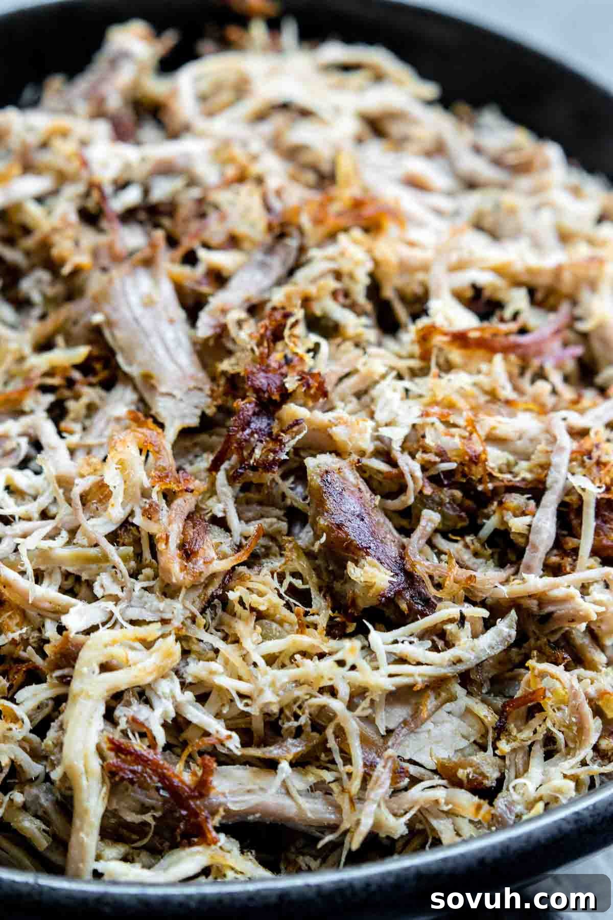 Close-up of crispy Slow Cooker Pulled Pork Carnitas in a black bowl, ready to serve
