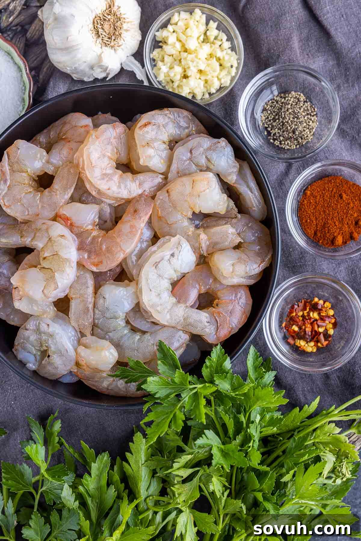 Sizzling Chili Garlic Shrimp 3 Fresh ingredients laid out for making Gambas Pil Pil: large shrimp, garlic, olive oil, paprika, red pepper flakes, parsley, salt, and pepper.