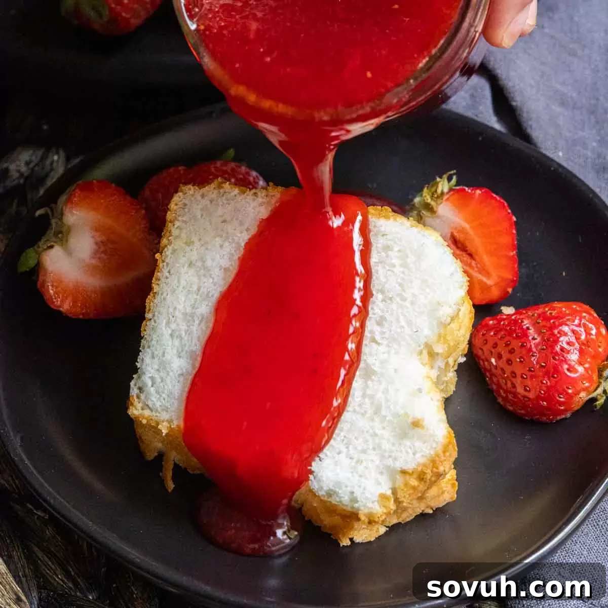 Delicious cake with homemade Strawberry Coulis being poured on