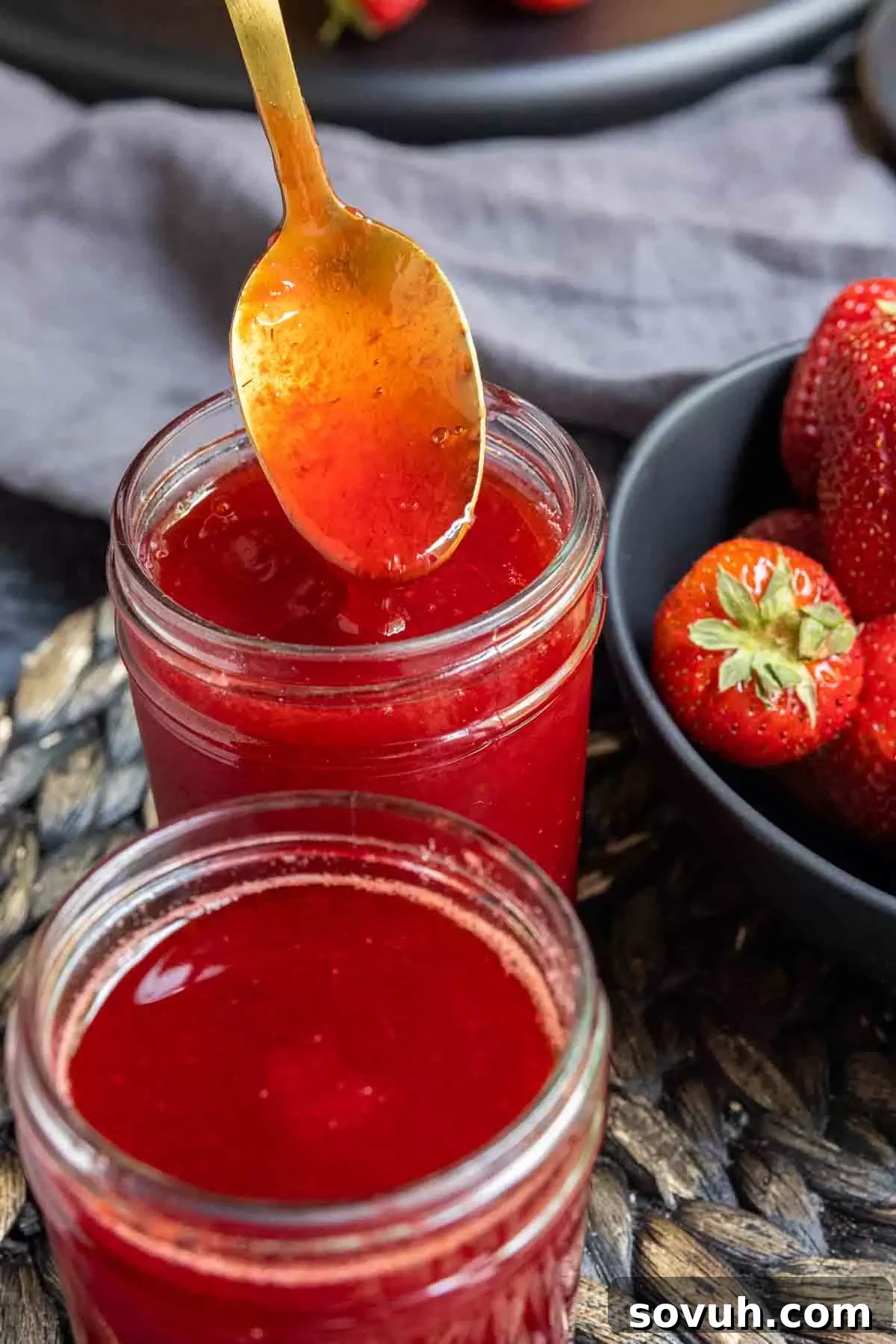 Strawberry Coulis on a gold spoon, showcasing its smooth texture