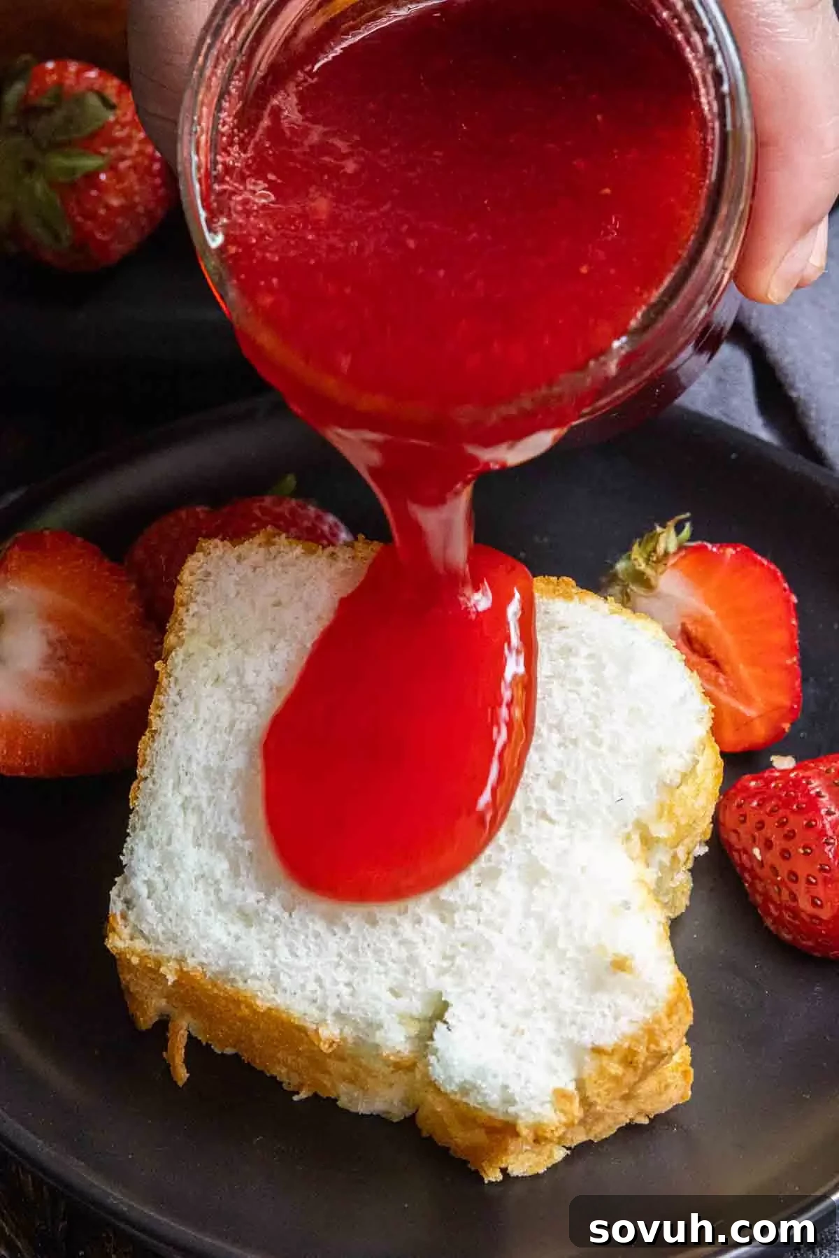 Pouring Strawberry Coulis over a slice of cake