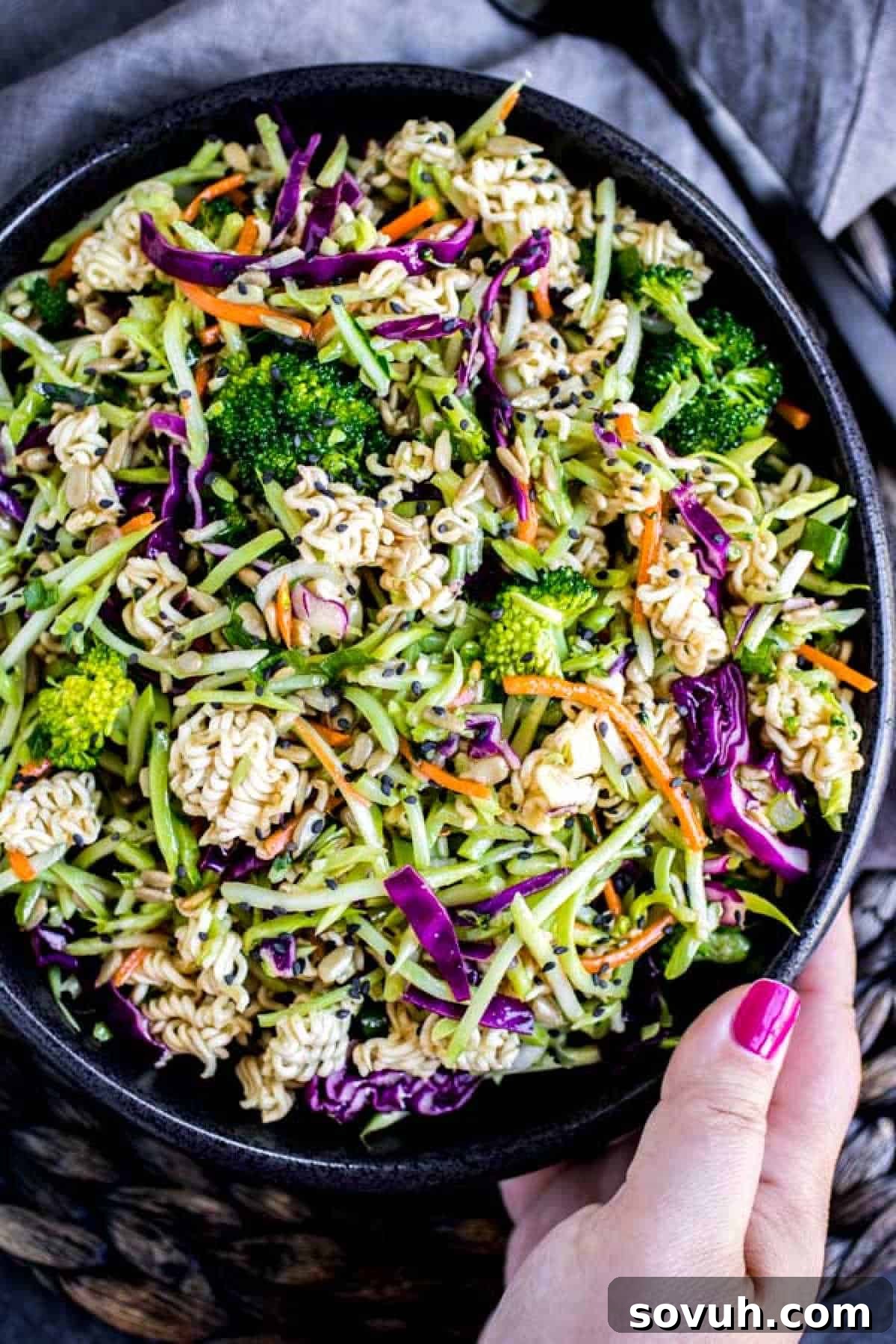 Crispy Ramen Slaw 6 holding a black bowl of Ramen Noodle Salad