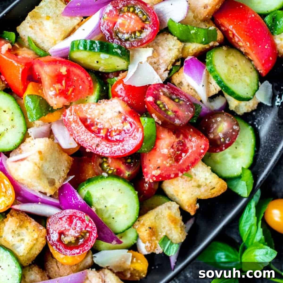 Panzanella Salad made with fresh garden vegetables and bread on a black platter