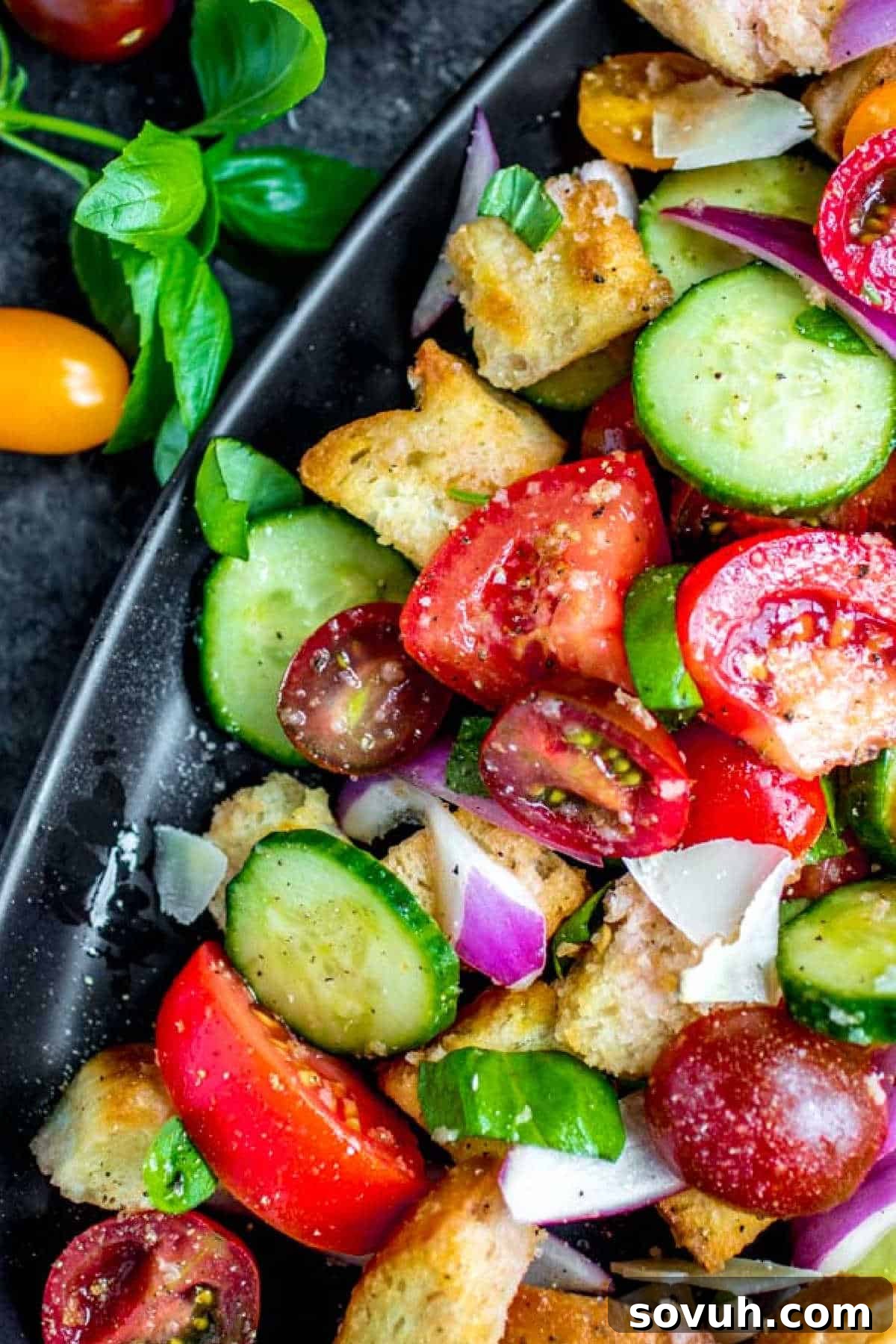 Panzanella Salad on a black platter with fresh basil