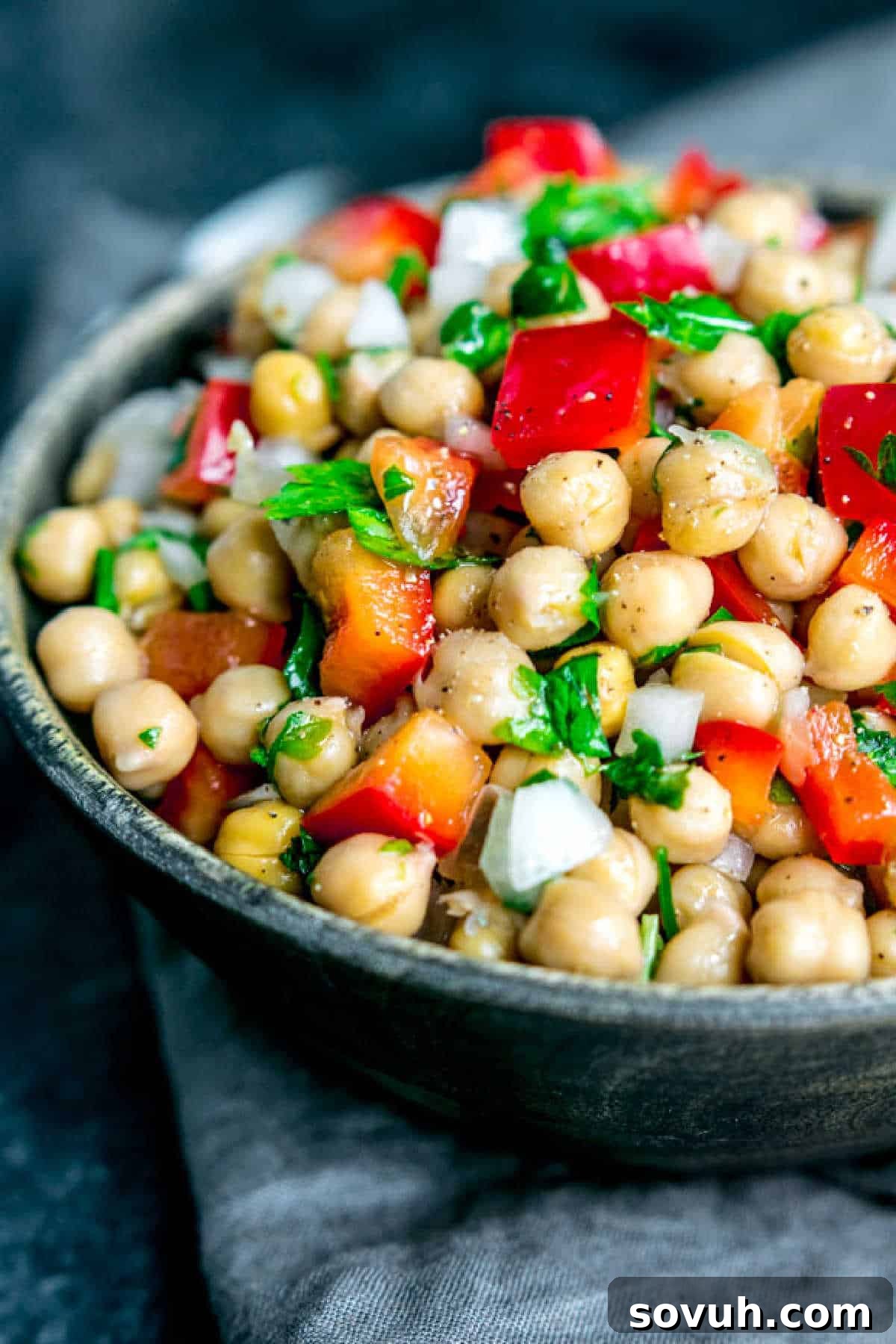 Close-up of Mediterranean Chickpea Salad featuring bright red bell peppers, onions, and plump chickpeas, ready to be enjoyed