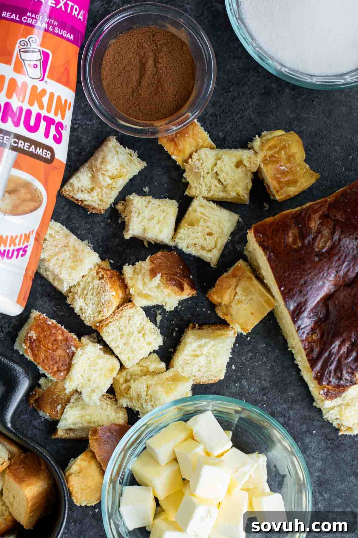 A carefully arranged collection of fresh ingredients for a Cinnamon Roll French Toast Casserole laid out on a rustic wooden table, highlighting their quality and readiness for baking.