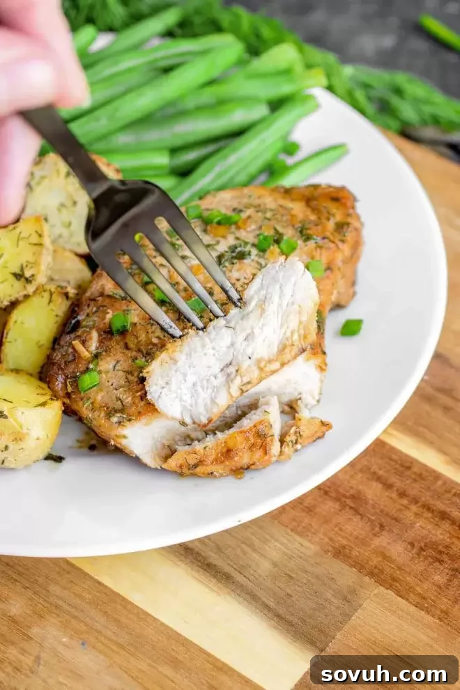 A perfectly cooked piece of Baked Ranch Pork Chops on a fork, showing its tender texture
