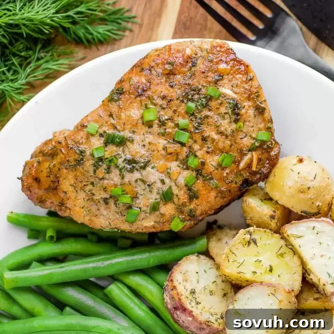 Baked Ranch Pork Chops on a rustic plate with corn on the cob and green beans