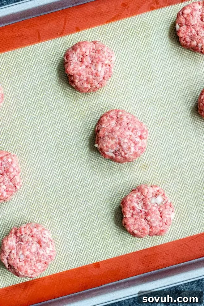 Mini raw burger patties for Keto Big Mac Bites on a baking sheet