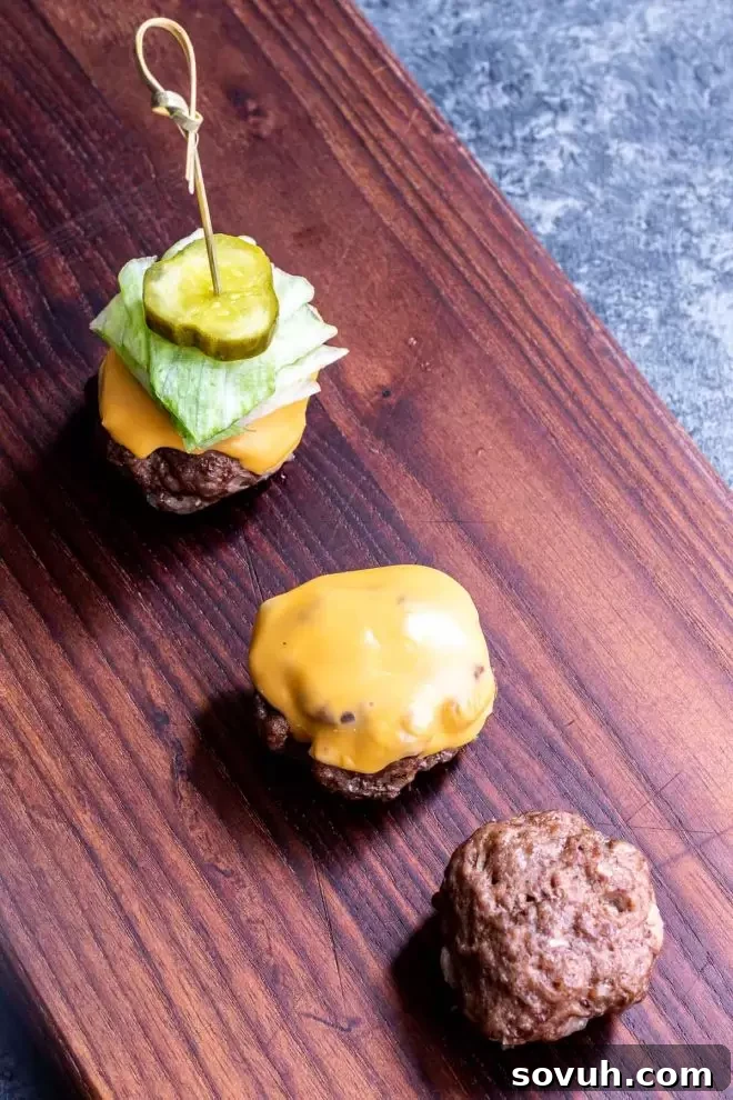 Assembling Keto Big Mac Bites with melted cheese and fresh toppings