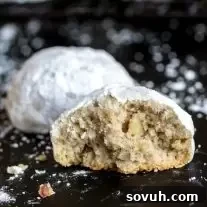 Half of a Mexican Wedding Cookie, dusted generously with powdered sugar.