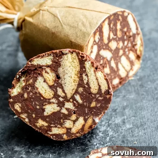 Delicious slice of Chocolate Salami with Maria biscuits visible, dusted with powdered sugar, ready to serve.