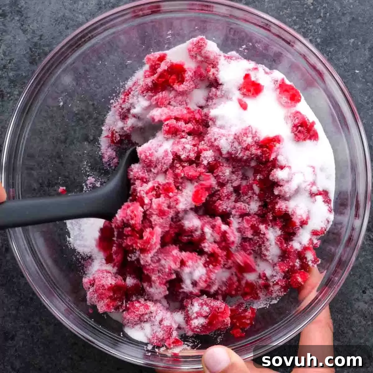 A bowl of Cranberry Fluff in preparation, showing the chopped cranberries and other ingredients before the whipped topping is added.