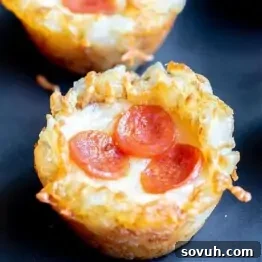 Close-up of a mini pizza cup made from hash browns, topped with melted cheese and three slices of pepperoni.