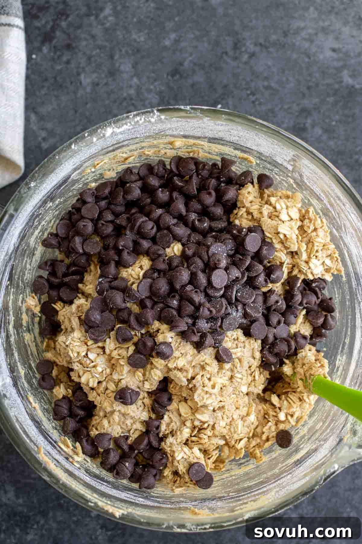 Ranger Cookies dough being mixed with chocolate chips, oats, and rice cereal for the final cookie batter