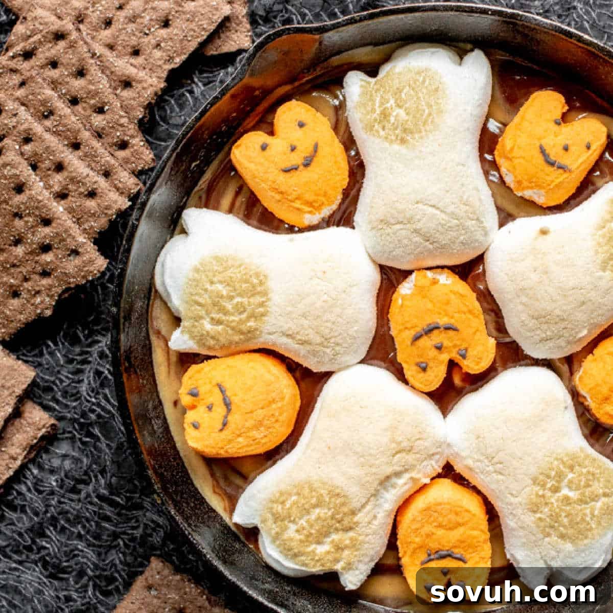 Halloween S'mores Dip baked in a skillet with festive Halloween Peeps over chocolate and peanut butter