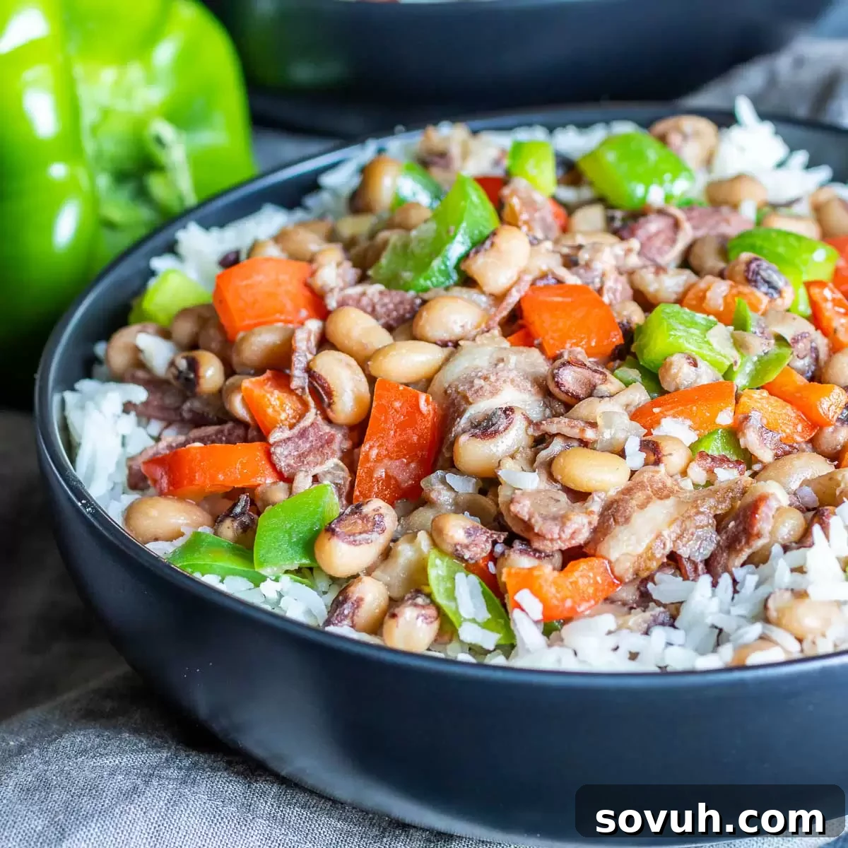 Hearty Instant Pot Hoppin' John served in a black bowl, garnished with fresh herbs.