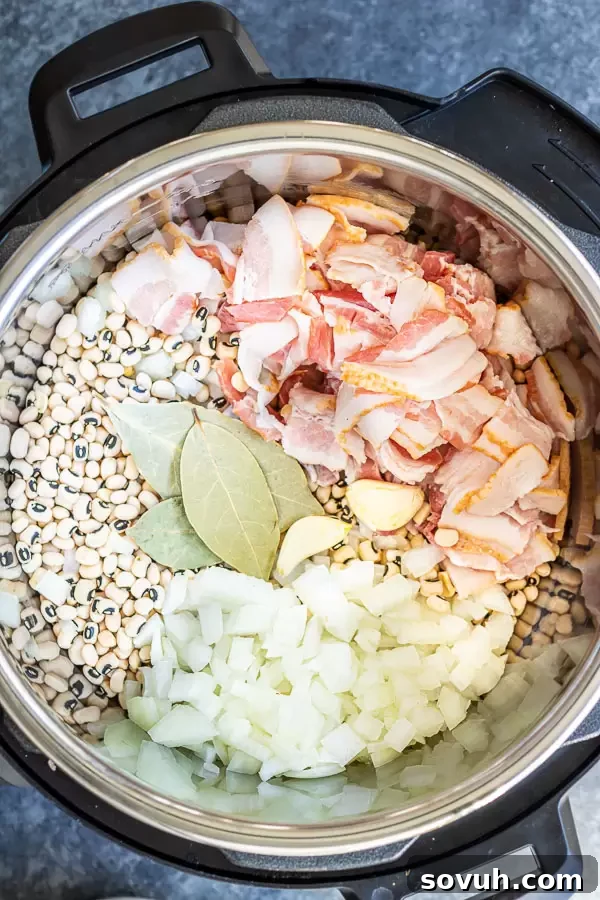 Array of fresh ingredients including black-eyed peas, bacon, and vegetables for Instant Pot Hoppin' John.