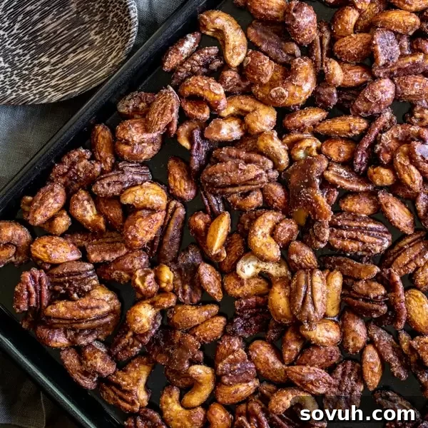 Sweet and spicy Slow Cooker Spiced Nuts on a baking sheet, ready for holiday gifting.