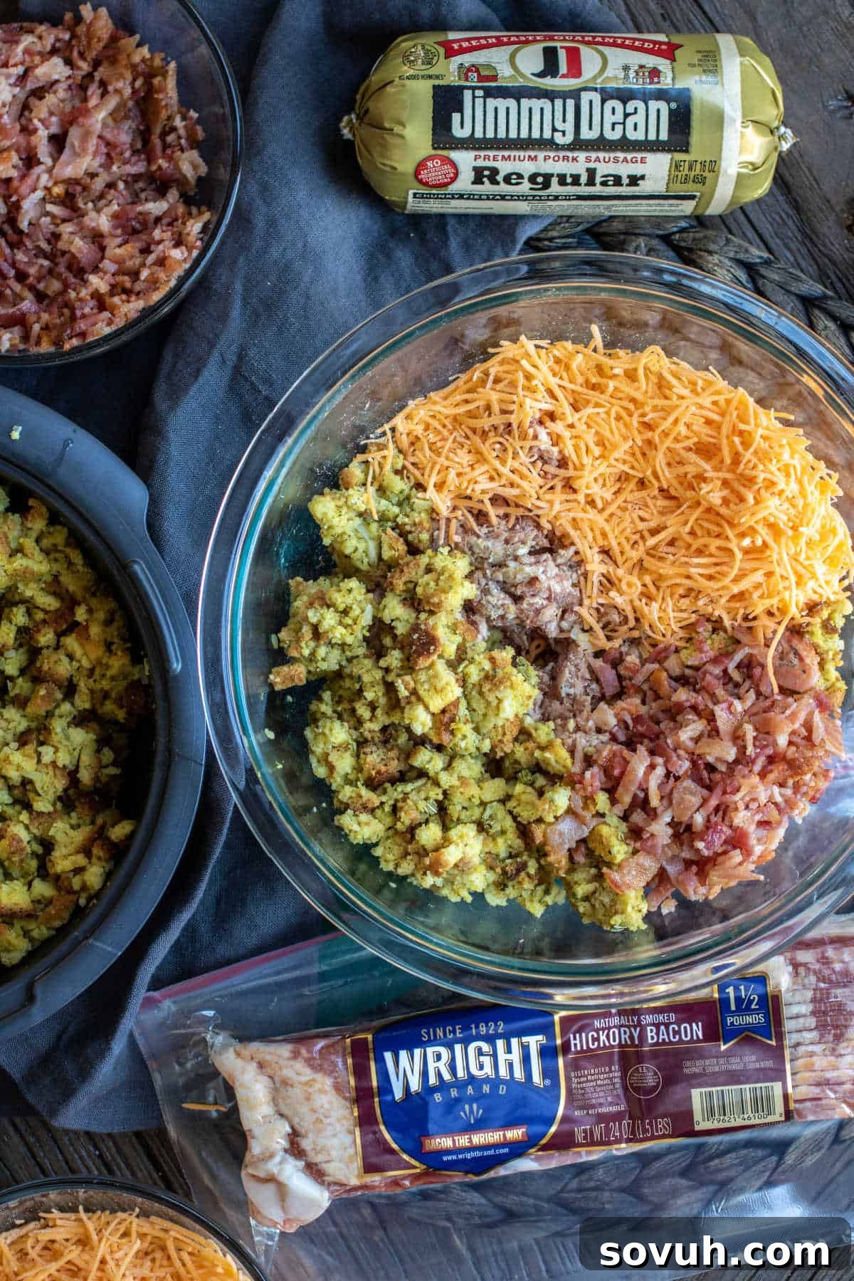 A vibrant display of fresh ingredients laid out for making Stuffing Balls, including ground sausage, cooked bacon, prepared stuffing mix, and shredded cheddar cheese.