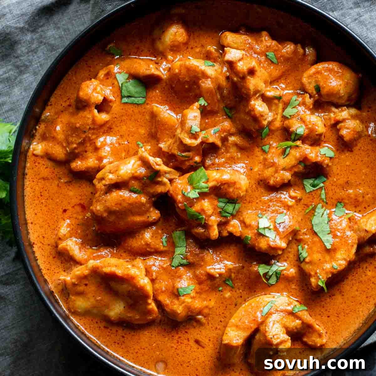 A bowl of Instant Pot Butter Chicken with a sauce and fresh herbs, perfect for a keto diet.