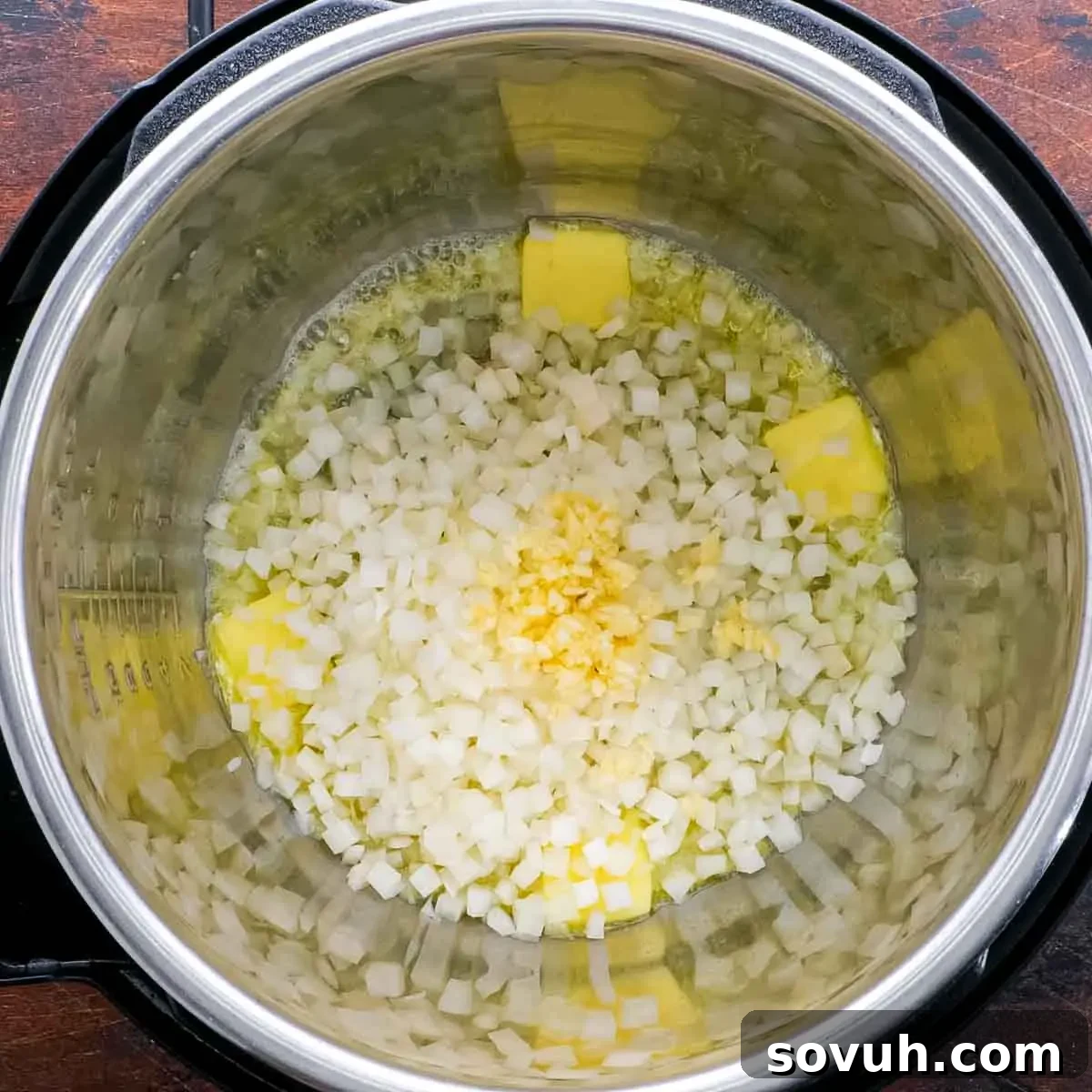 An Instant Pot filled with sautéed onions and garlic, beginning the process of making Keto Butter Chicken.