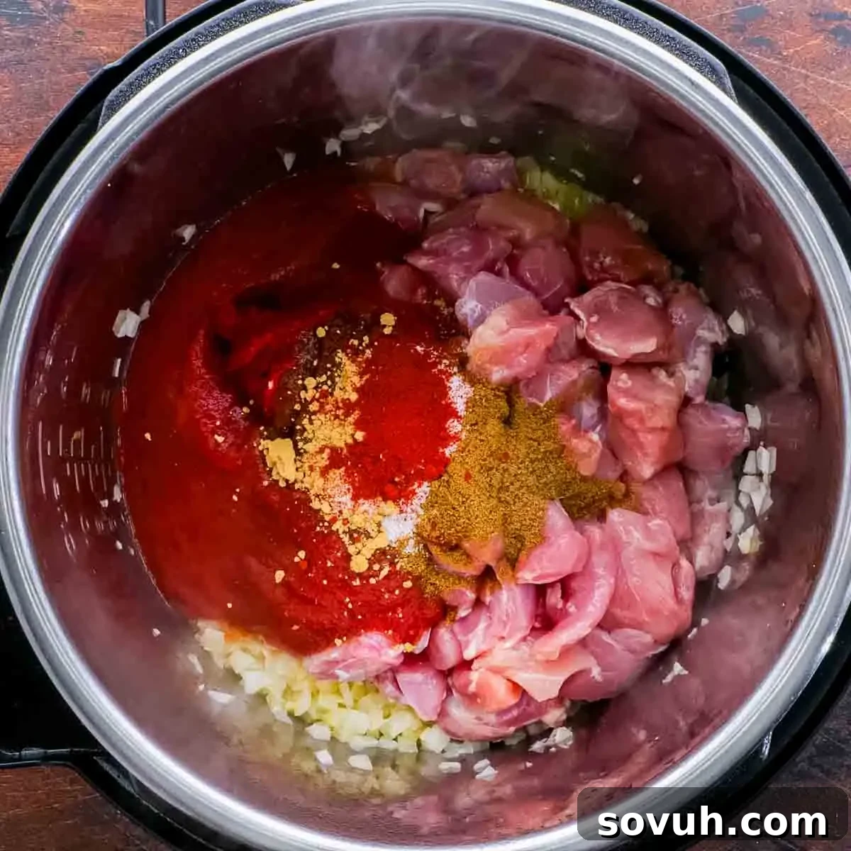 The Instant Pot containing all the ingredients for Butter Chicken before pressure cooking, showcasing the rich colors of the sauce.