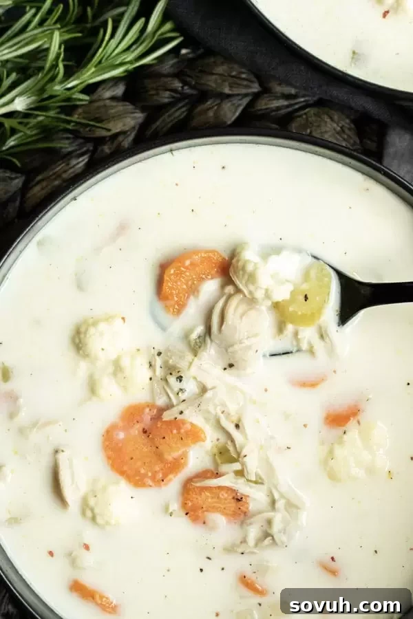 A steaming bowl of Instant Pot Low Carb Creamy Chicken Soup, showing cauliflower and shredded chicken.