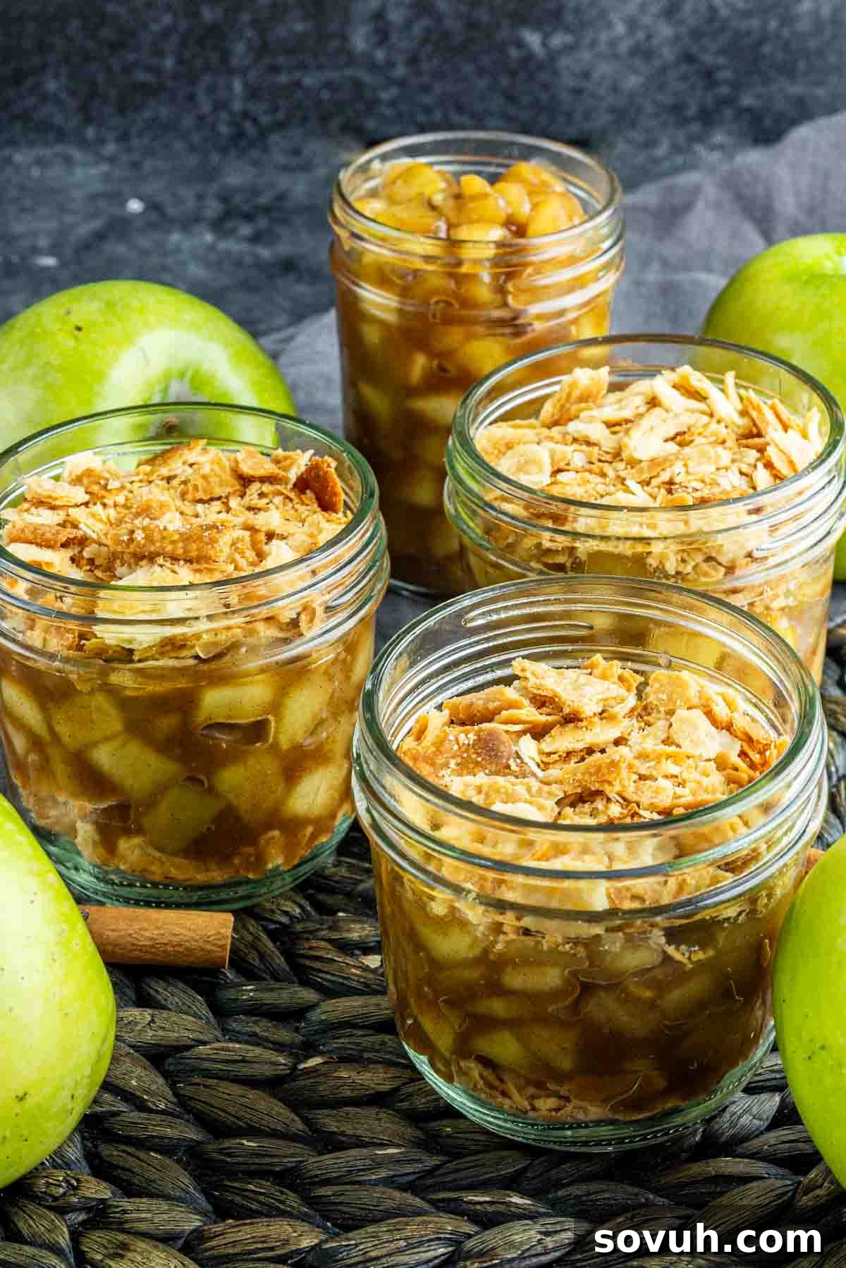 apple pie in a jar on a table with apples and cinnamon