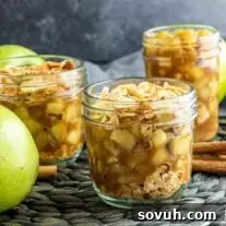 apple pie in a jar on a table with apples and cinnamon