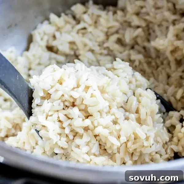 Instant Pot Brown Rice in a serving bowl, garnished with fresh herbs.