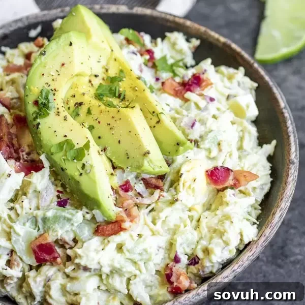 Delicious, creamy avocado chicken salad served in a bowl, garnished with fresh herbs, perfect for a low-carb and keto lunch.