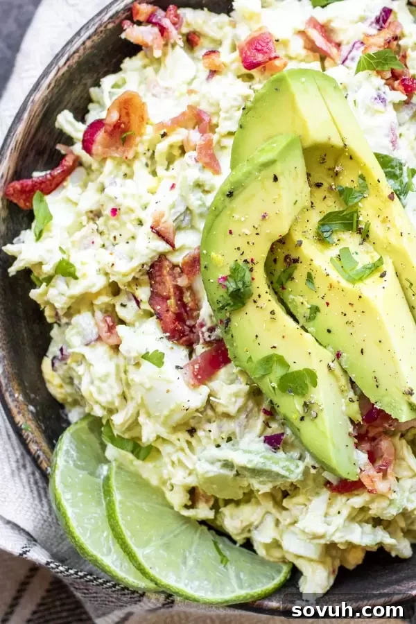 A bowl of freshly made avocado chicken salad, ready to be served or enjoyed, highlighting its creamy texture and visible ingredients.