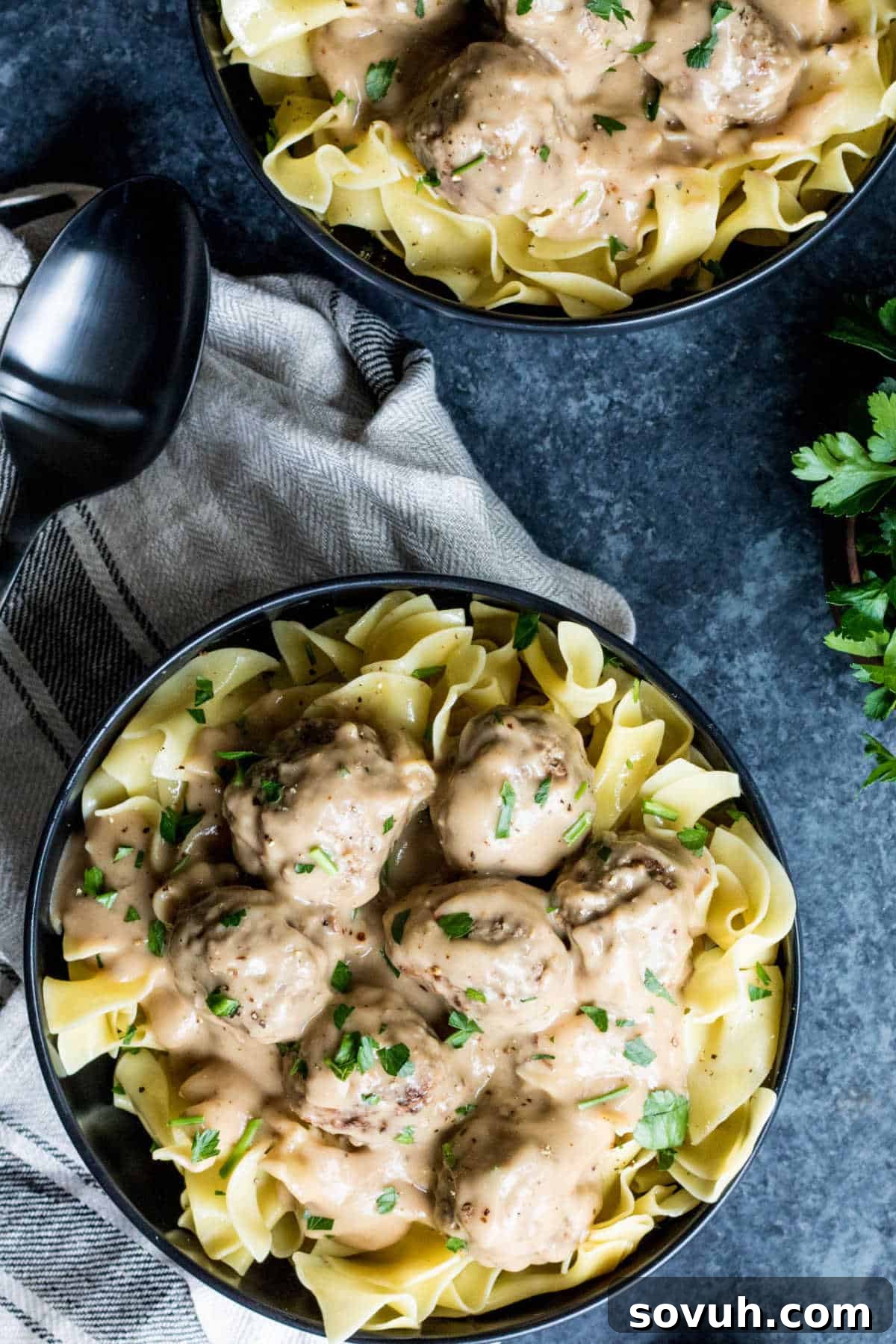 Top down shot of swedish meatballs in sauce over egg noodles