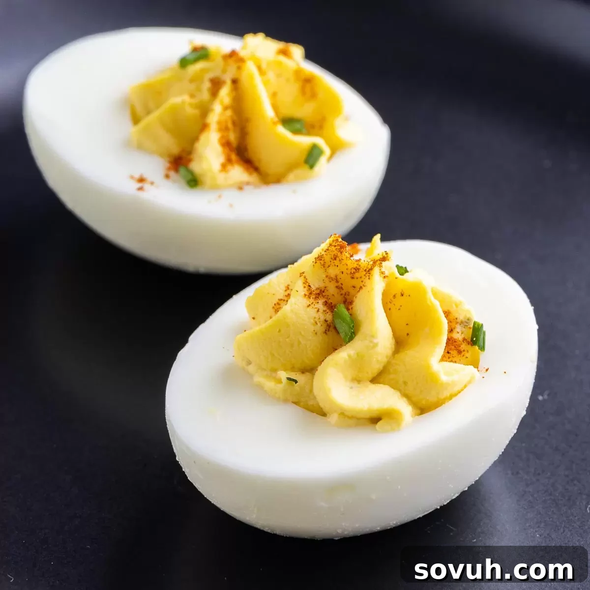 two Southern Deviled Eggs on a black plate