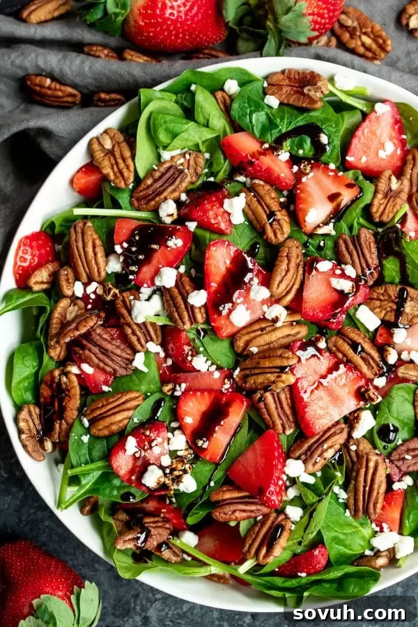 Strawberry & Spinach Salad topped with pecans and goat cheese