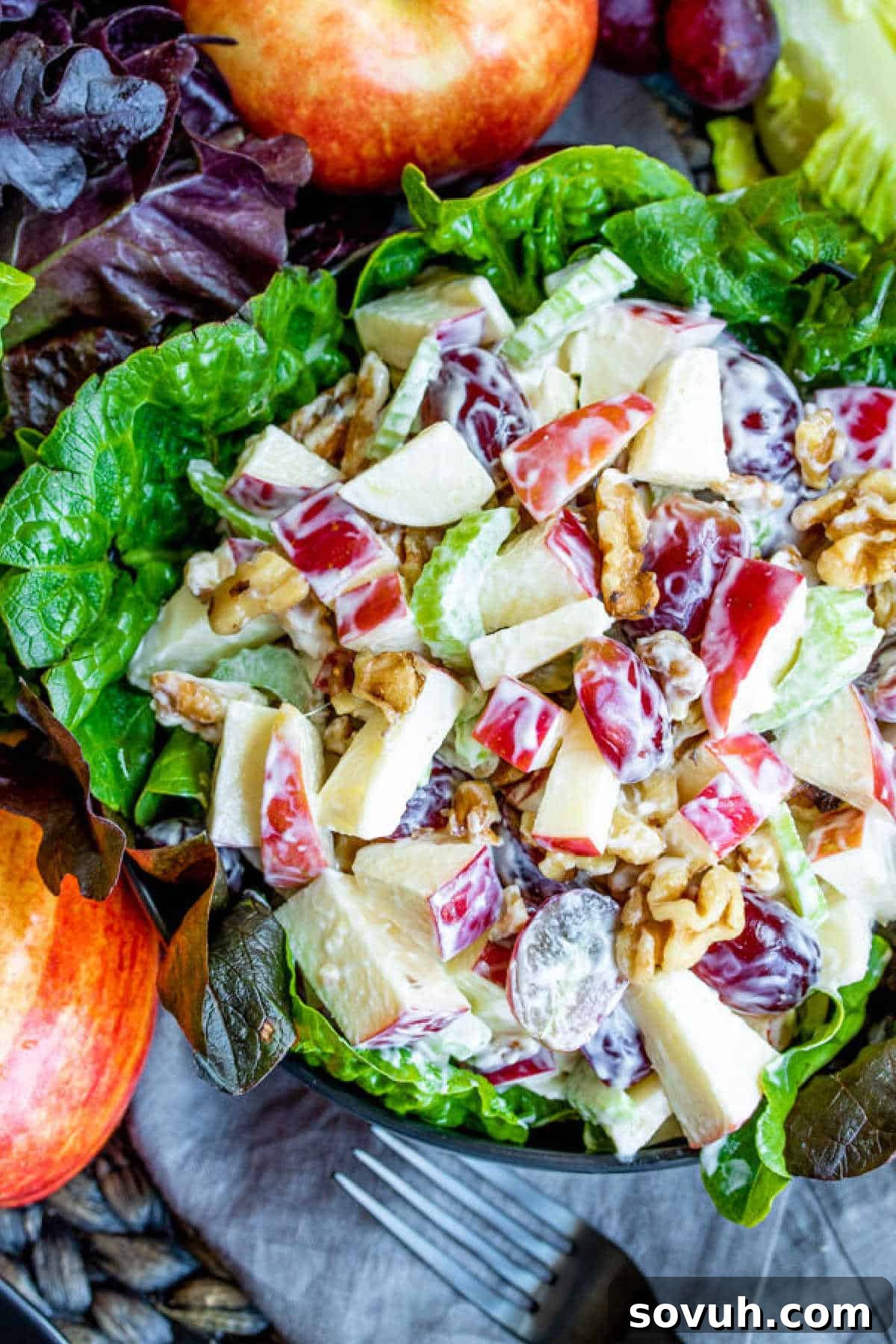 Individual lettuce cup filled with Waldorf Salad, featuring apples, grapes, and walnuts.