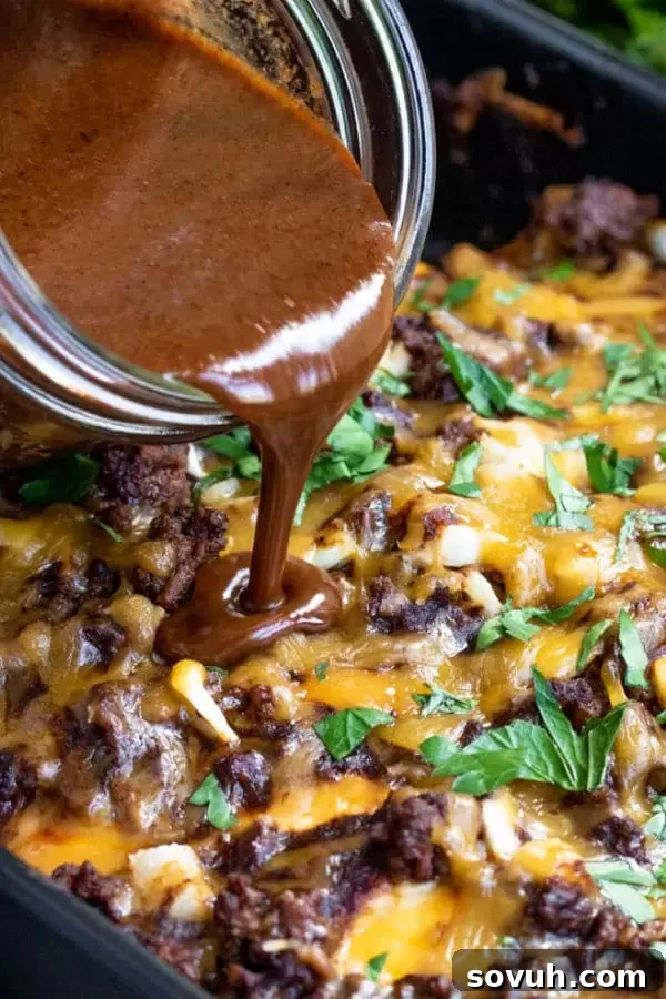 Pouring Homemade Red Enchilada Sauce over freshly made enchiladas