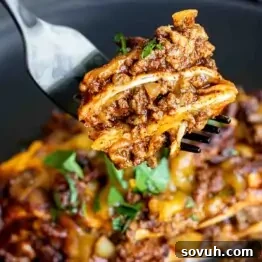 A fork is being used to pick up a piece of Beef Enchilada Casserole