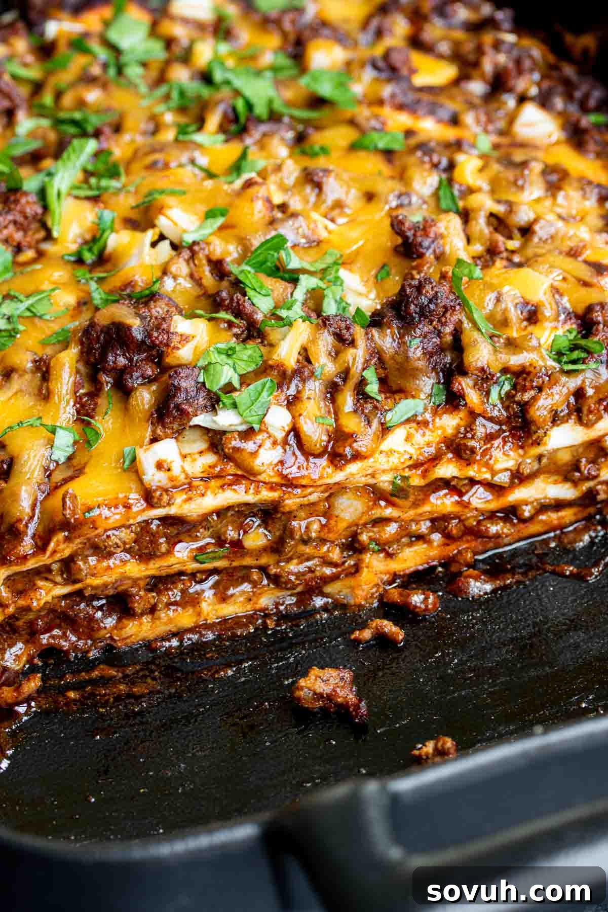 A large skillet filled with cooked Beef Enchilada Casserole, ready to be served.