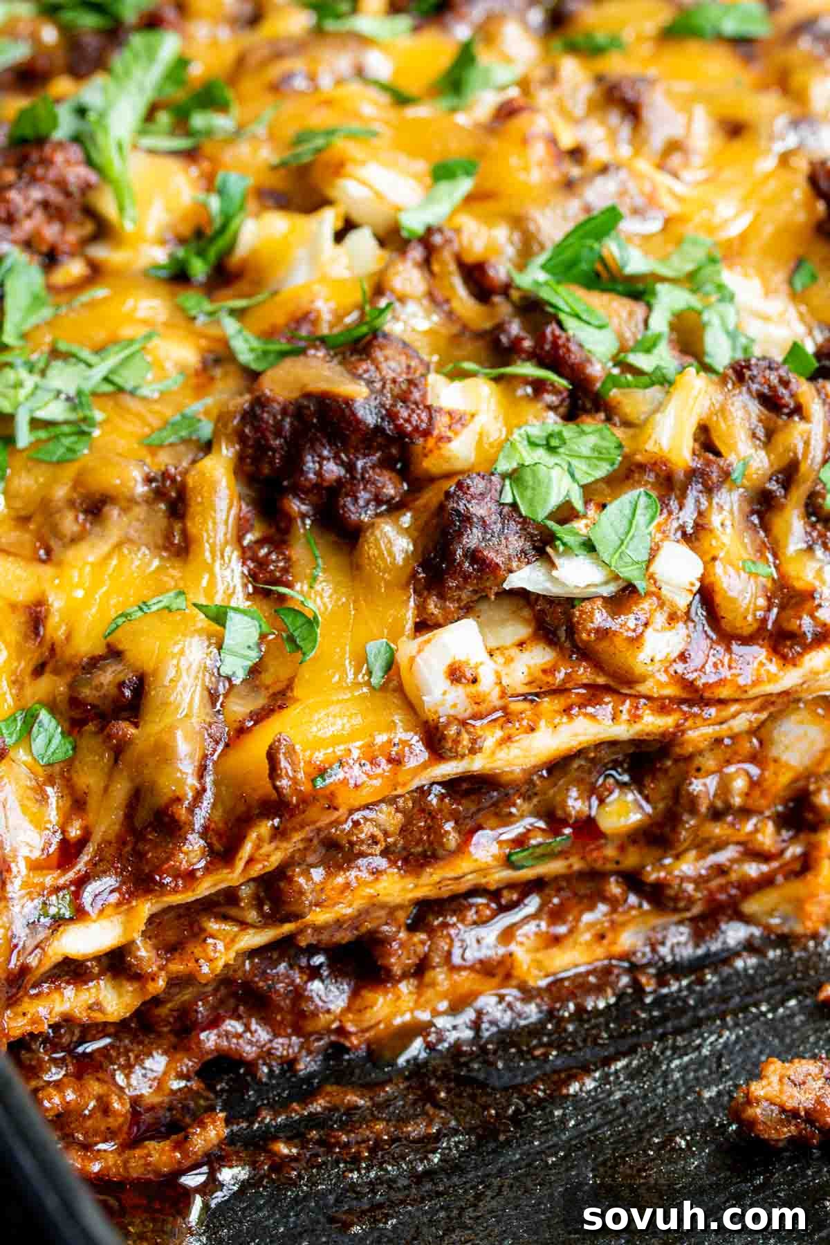 A large, golden-brown Beef Enchilada Casserole resting in a baking dish after being removed from the oven.