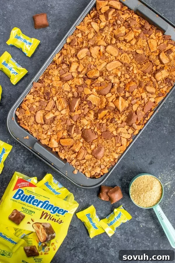 Topping Butterfinger S'mores Bars with chopped Butterfinger Minis, pressed into the fudge