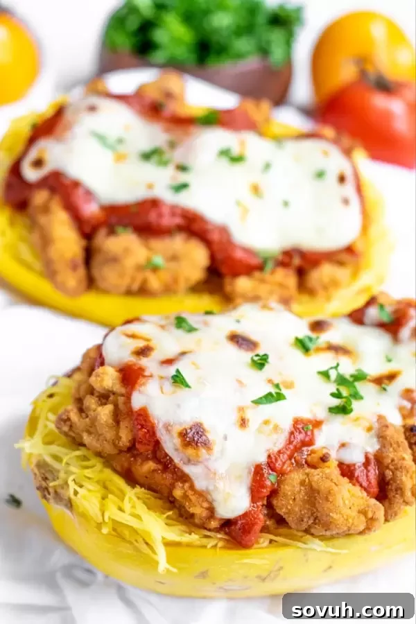Chicken Parmesan roasted spaghetti squash served directly in the cooked squash halves, garnished with fresh herbs.