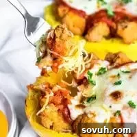 A fork digging into chicken parmesan roasted spaghetti squash