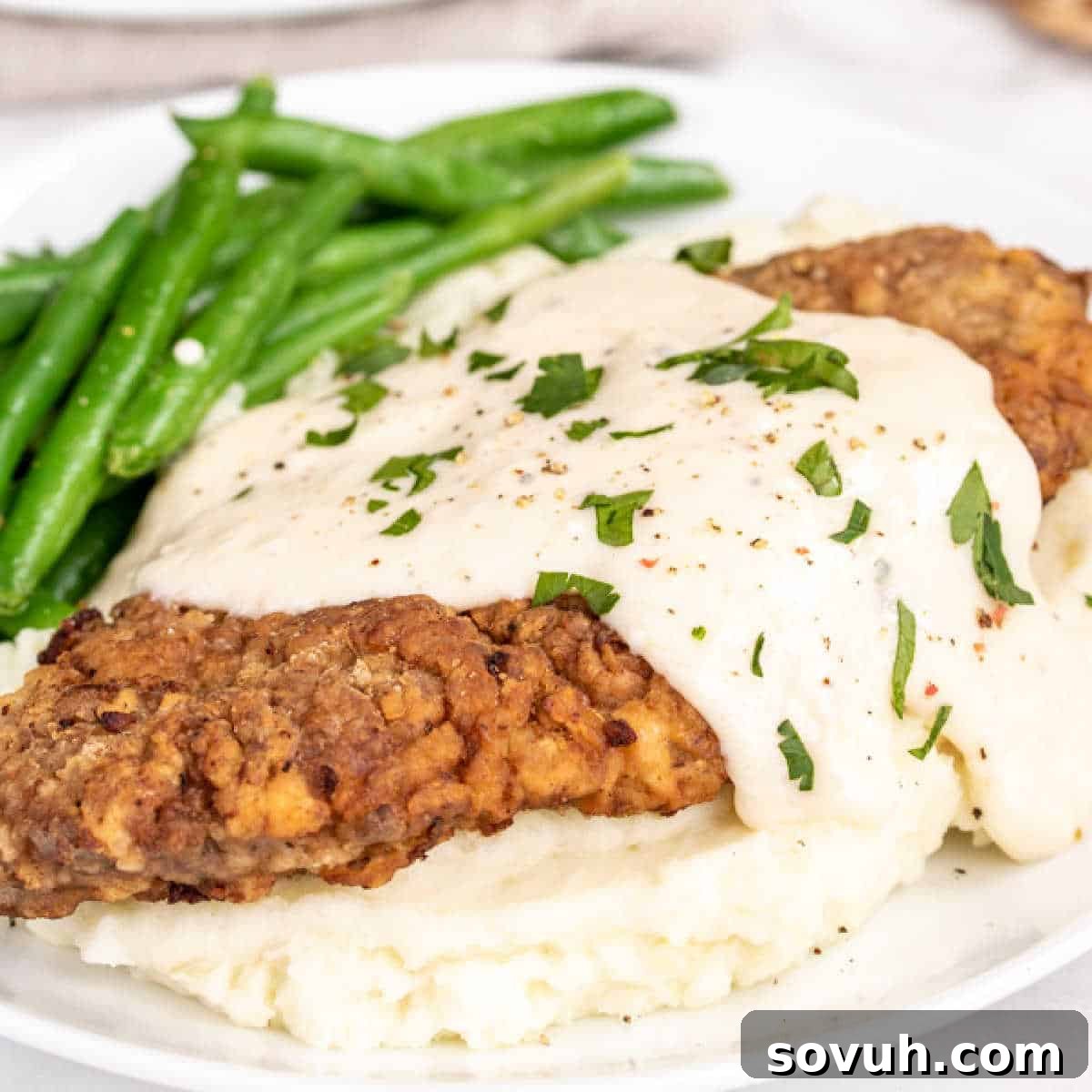Chicken Fried Steak with Gravy on a white plate, ready to be enjoyed