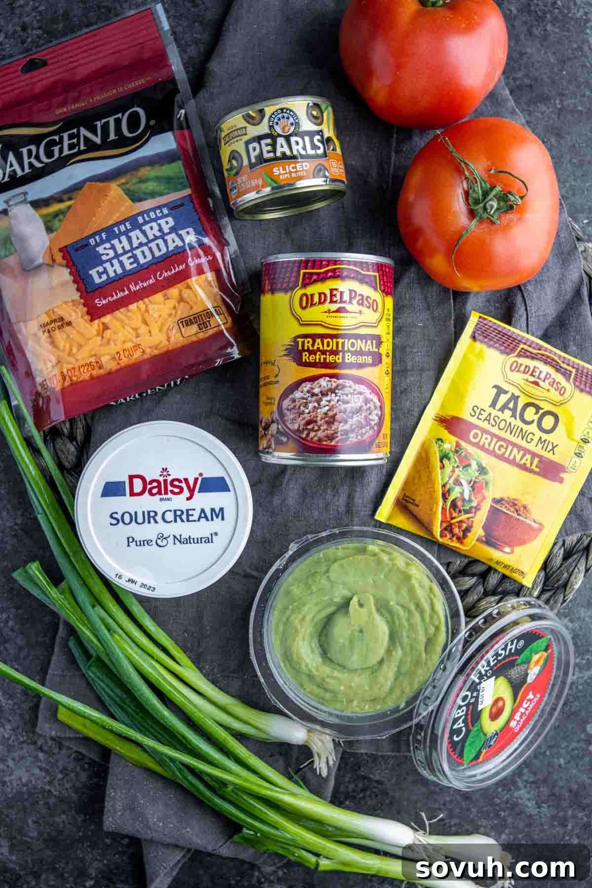 All the fresh ingredients for Mexican 7 Layer Dip laid out on a table